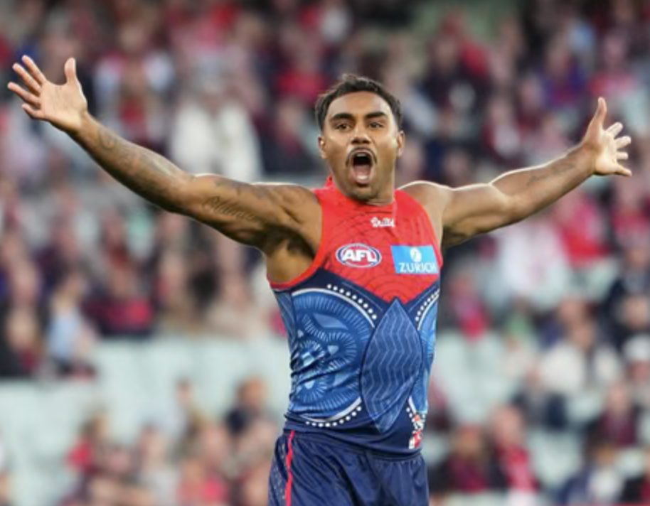 An AFL forward celebrates a goal in front of the crowd