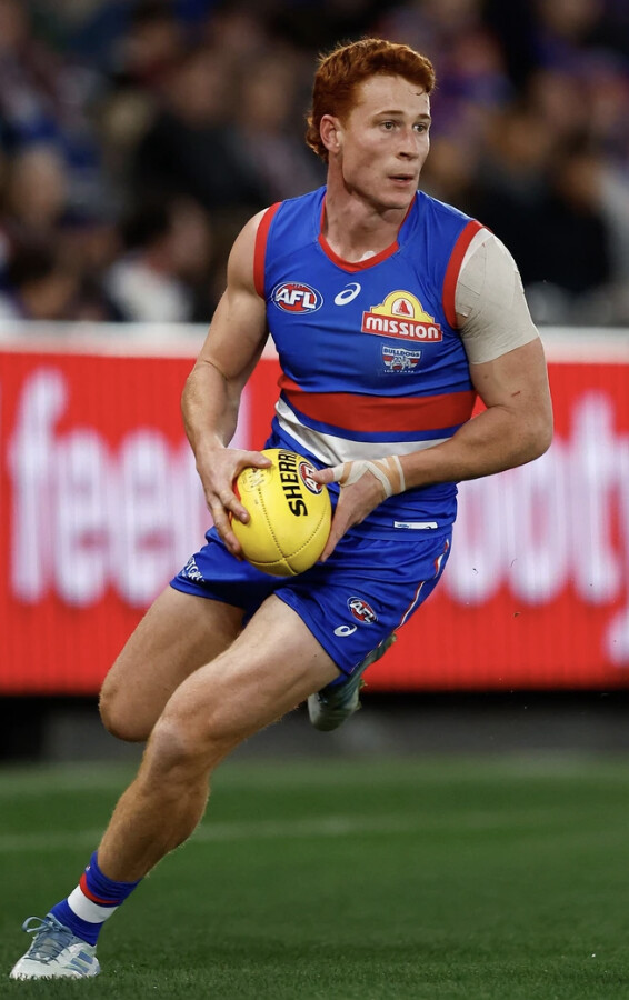 A Western Bulldogs player runs the ball forward — the Dogs survive the wildcard round and play on