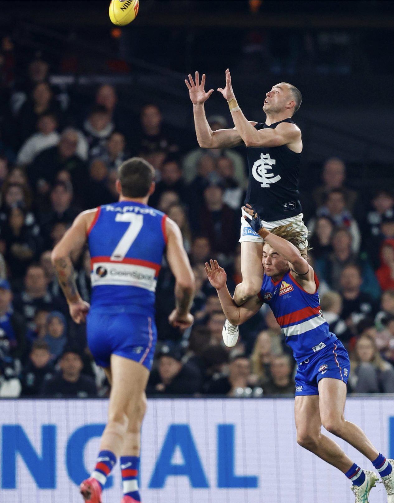 A Carlton player takes a high mark over Western Bulldogs opponents